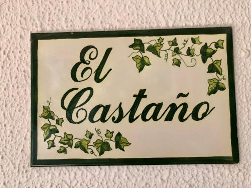 een bord dat aan een muur hangt met groene bladeren bij LA CASA del CASTAÑO in Aracena