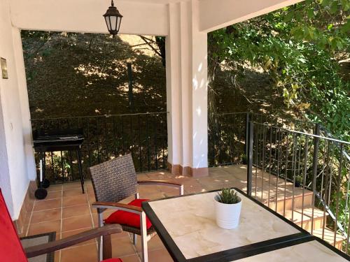 een afgeschermde veranda met een tafel en stoelen bij LA CASA del CASTAÑO in Aracena