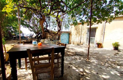 a wooden table with chairs under a tree at DC Family Home & Garden - Traditional village house in Pano Arodes
