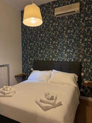 a bedroom with a large bed with a floral wallpaper at NOI Luxury rooms Colosseum in Rome