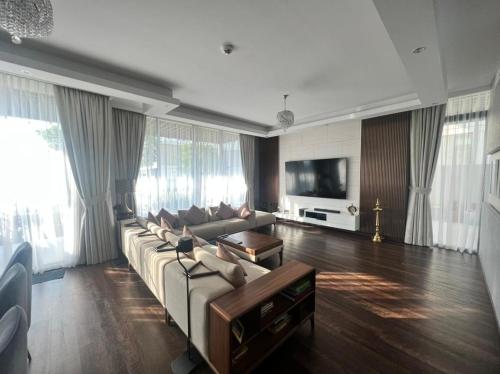 a large living room with a couch and a tv at Private room in a luxury villa at Dubai hills in Dubai