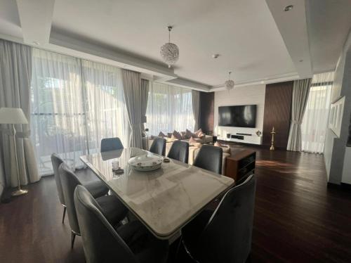 a living room with a dining table and a couch at Private room in a luxury villa at Dubai hills in Dubai