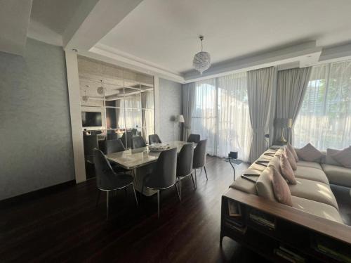 a living room with a couch and a table and chairs at Private room in a luxury villa at Dubai hills in Dubai