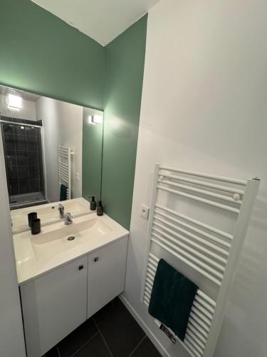 a bathroom with a sink and a mirror at Modern garden apartment in Labenne