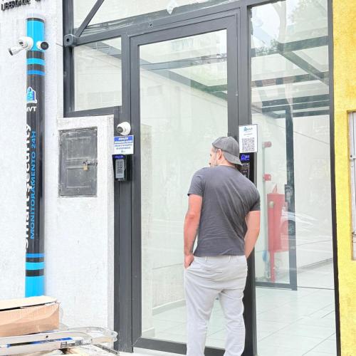 a man standing in front of a glass door at 104NV Studio Liberdade SP 300 m Metro Japao, acomoda até 03 pessoas in Sao Paulo