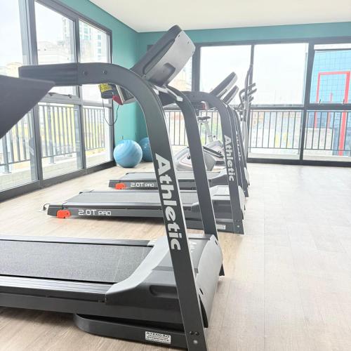 a gym with several treadmills in a room with windows at 104NV Studio Liberdade SP 300 m Metro Japao, acomoda até 03 pessoas in Sao Paulo