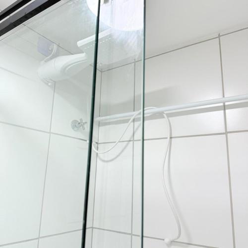a shower in a bathroom with a glass door at 104NV Studio Liberdade SP 300 m Metro Japao, acomoda até 03 pessoas in Sao Paulo