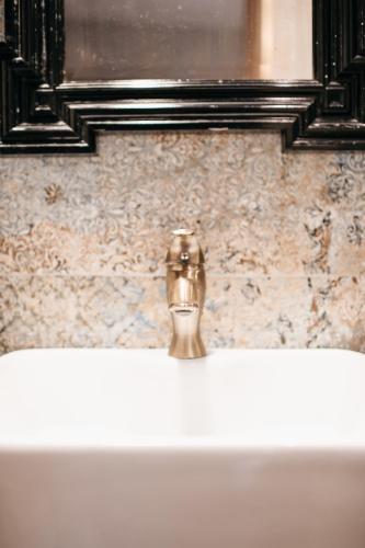 a bathroom sink with a gold faucet at Uroczysko Oleśnica in Chodzież