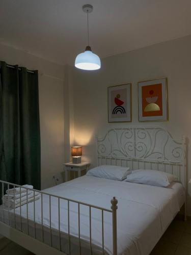 a bedroom with a white bed and a lamp at Casa StefanoS in Afitos