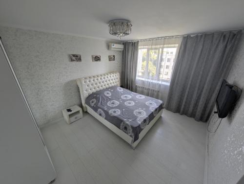 a bedroom with a bed and a window at Black and White apartment in Chişinău
