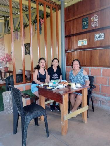 a group of three women sitting at a table at Heliconia's Inn in Puerto Maldonado
