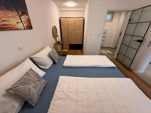 a room with two beds and a hallway at Neue und sonnige Doppelhaushälfte in Dobl bei Graz Top 2 in Dobl