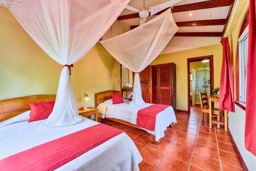 a bedroom with two beds in a room at Hotel El Encanto in Cahuita
