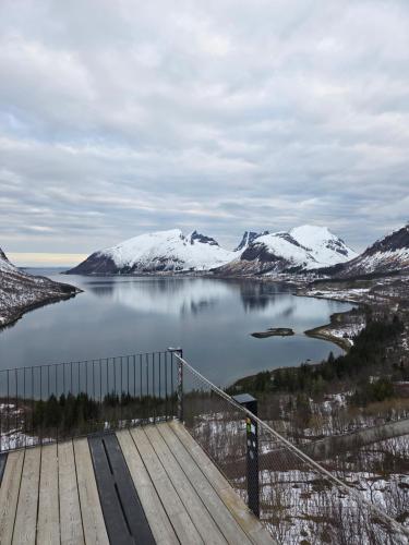 a view of a lake with snow covered mountains at Havblikk in Gryllefjord