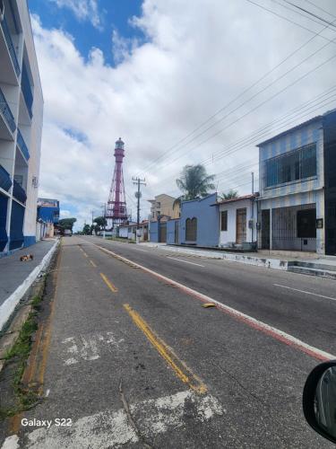 an empty street with a tower in the distance at Casa salinas prox orla in Salinópolis
