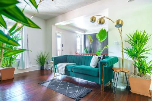 a living room with a blue couch and plants at Jungle House Columbus Short North Downtown Free Parking - Steps to Convention Center & Nationwide Arena - 2BR Luxury Home - Sleeps 8 - Over 5,800 Five Star Stays in Columbus
