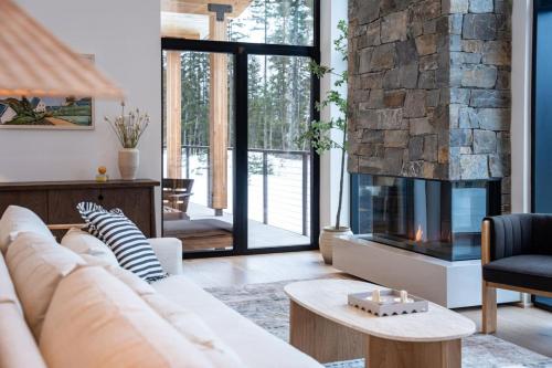 un soggiorno con divano e camino di Ghost Peak Chalet - Ski-In Access a Port Mann