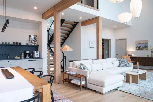 un soggiorno con un divano bianco e una scala di Ghost Peak Chalet - Ski-In Access a Port Mann