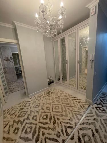 キシナウにあるModern Apartament Centru Rîșcaniのシャンデリアのある廊下とカーペットが敷かれた部屋