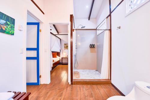 a bathroom with a shower with a glass door at Hotel El Encanto in Cahuita