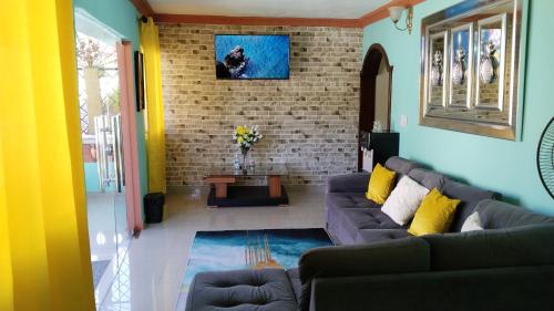 Una sala de estar con un sofá y una pared de ladrillos. en Doña Nida Family Hotel, en Santa Cruz de Barahona