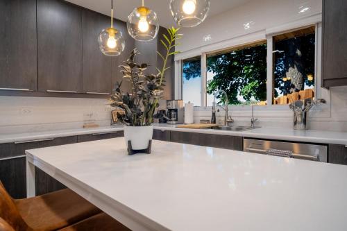 a kitchen with a large white counter with a vase of flowers at 3Bed 2Bath Luxury Lake House on Myers Bay Private Pier Beach Firepit and Deck in Fox Lake