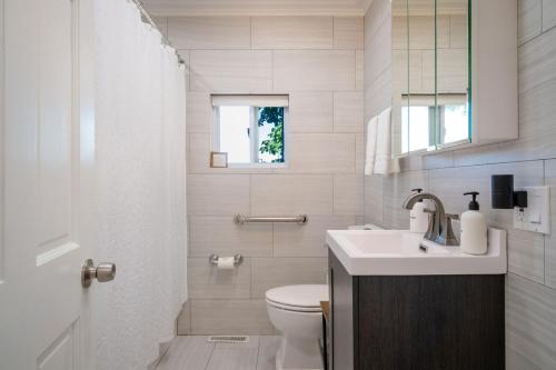 a white bathroom with a toilet and a sink at 3Bed 2Bath Luxury Lake House on Myers Bay Private Pier Beach Firepit and Deck in Fox Lake