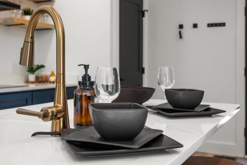 セバービルにあるHoneyscape Treehouse HotTub Intimate Getaway Firepitの2枚の皿とグラス、シンクを備えたキッチンカウンター