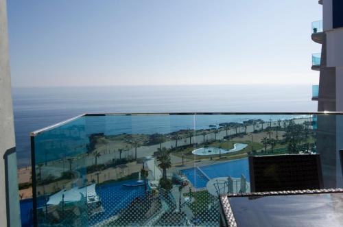 a balcony with a view of a pool and the ocean at Sea Senses by Mar Holidays in Torrevieja