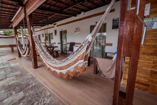 a couple of hammocks hanging from a building at Casa c 5 suites, Piscina, Churrasqueira e Sinuca in Cabedelo