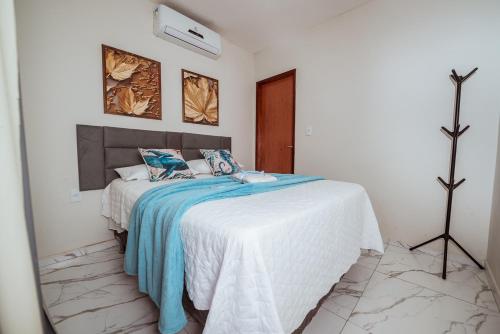 a bedroom with a bed with a blue blanket at Casa c 5 suites, Piscina, Churrasqueira e Sinuca in Cabedelo