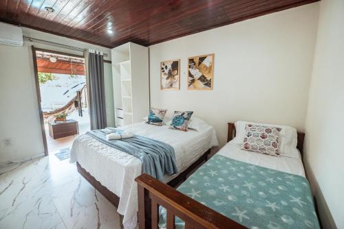 a bedroom with two beds and a balcony at Casa c 5 suites, Piscina, Churrasqueira e Sinuca in Cabedelo