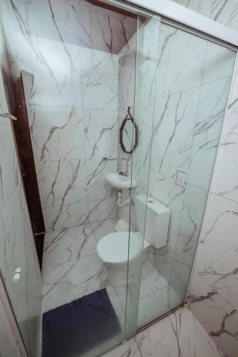 a bathroom with a glass shower with a toilet at Casa c 5 suites, Piscina, Churrasqueira e Sinuca in Cabedelo