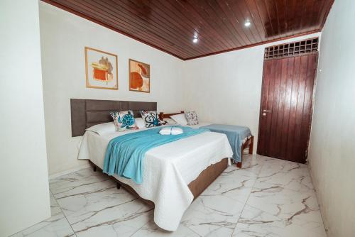 a bedroom with a bed with blue and white sheets at Casa c 5 suites, Piscina, Churrasqueira e Sinuca in Cabedelo