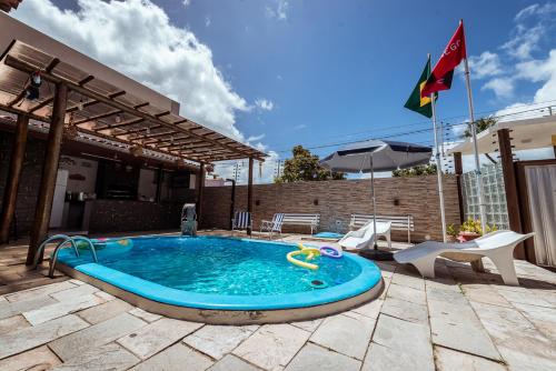 a small swimming pool in a patio with a flag at Casa c 5 suites, Piscina, Churrasqueira e Sinuca in Cabedelo