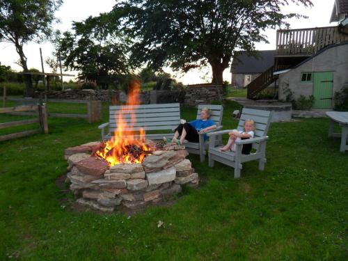 two people sitting around a fire pit in a yard at Mellby Ör Inn in Mellby