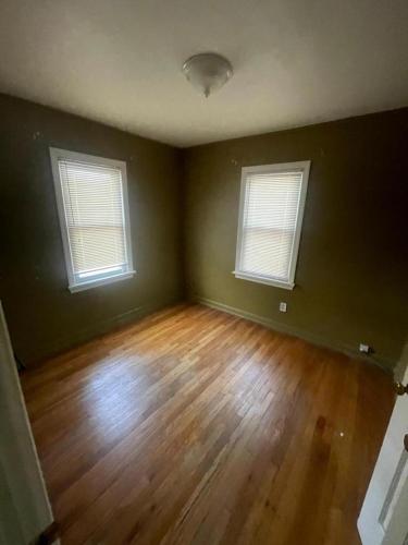 an empty room with two windows and a wooden floor at Duncan Enterprise Homes in Akron