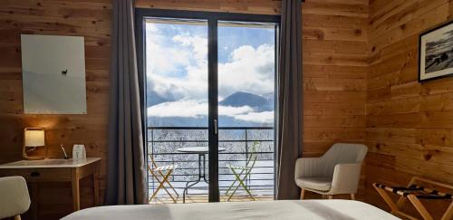 a bedroom with a view of a mountain through a window at Balcons de Sorgeat - Chambres d'hôtes - Ecolodge en montagne in Sorgeat