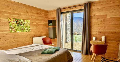 a bedroom with a bed and a large window at Balcons de Sorgeat - Chambres d'hôtes - Ecolodge en montagne in Sorgeat