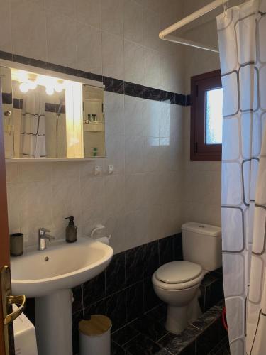 a bathroom with a sink and a toilet at Casa StefanoS in Afitos