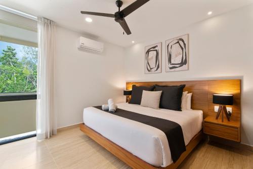 a bedroom with a large bed and a window at Luxury Jungle Condos by Casago in Tulum