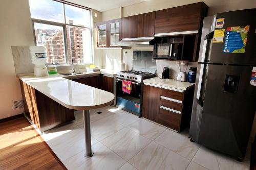 a kitchen with a black refrigerator and a stove at Confortable and modern, 14th Floor in La Paz