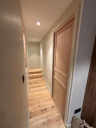 a hallway with a wooden door and a staircase at Les chambres de la Villa Oberlin in Beblenheim