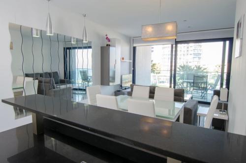 a dining room with a table and white chairs at Sea Senses by Mar Holidays in Torrevieja