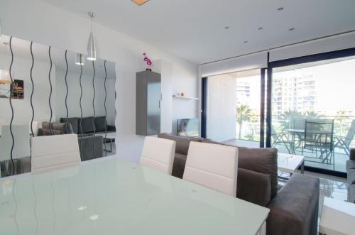 a dining room with a white table and chairs at Sea Senses by Mar Holidays in Torrevieja