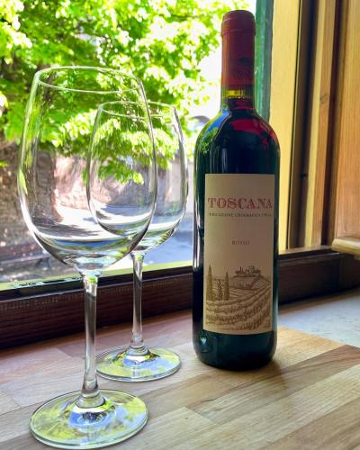 a bottle of wine and two wine glasses on a table at Le Giuggiole in Tuscany in Usigliano
