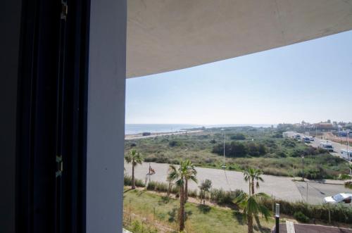 a room with a view of a beach with palm trees at Sea Senses by Mar Holidays in Torrevieja