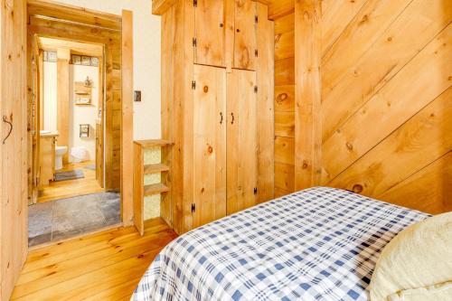 a bedroom with wooden walls and a bed in a room at 7 Mi to Glens Falls Peaceful Retreat with Game Room 