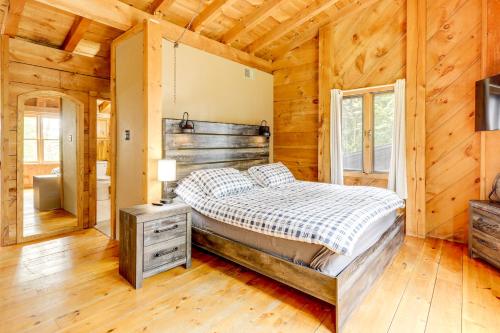 a bedroom with a bed in a log cabin at 7 Mi to Glens Falls Peaceful Retreat with Game Room 