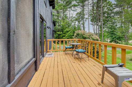 a wooden deck with a table and chairs on it at 7 Mi to Glens Falls Peaceful Retreat with Game Room 